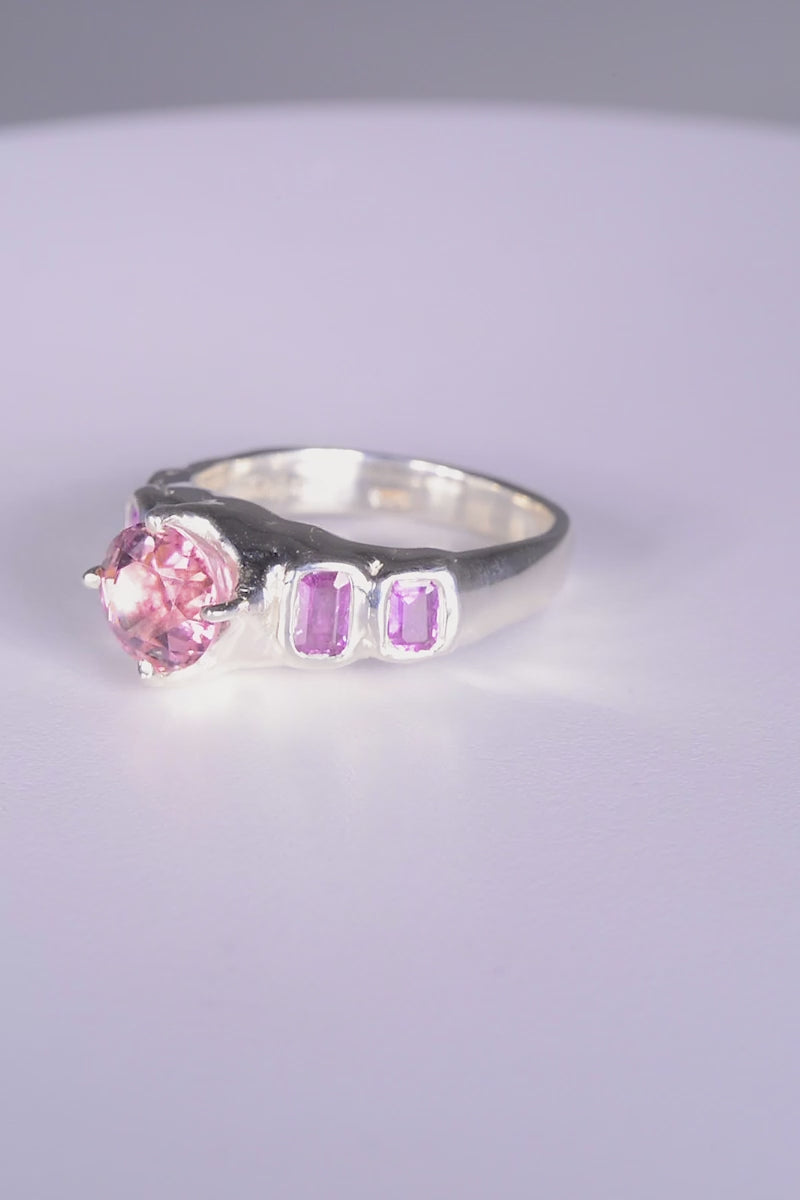 Pink Juice Ring
sterling silver
~ 8mm round cut pink tourmaline
~ two 4.5x3mm emerald cut purple sapphire
~ two 3.5x3mm emerald cut purple sapphire